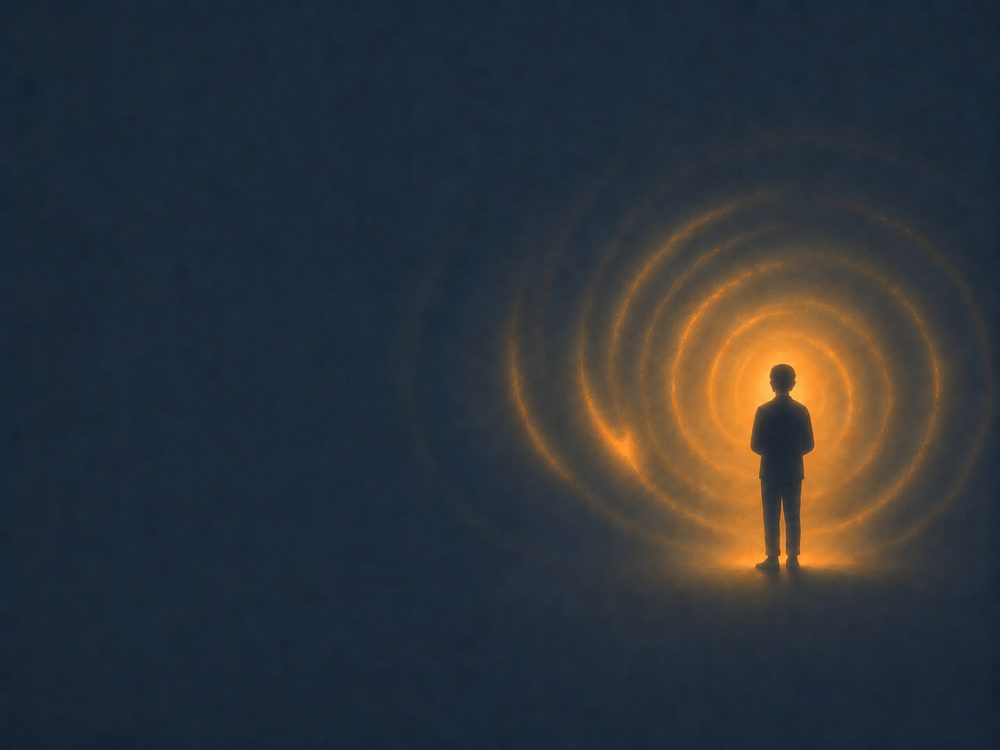 Silhouette de dos d'une personne au cœur d'une grande spirale de lumière orange sur un fond sombre.