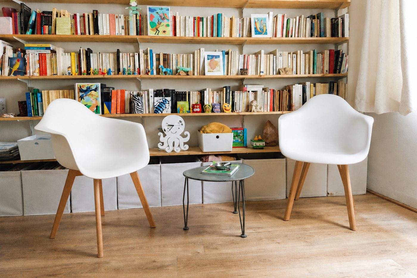 Le cabinet de consultation chaleureux et accueillant avec ses deux fauteuils blancs et sa bibliothèque à Nantes, illustrant le lieu de vos séances de thérapie.