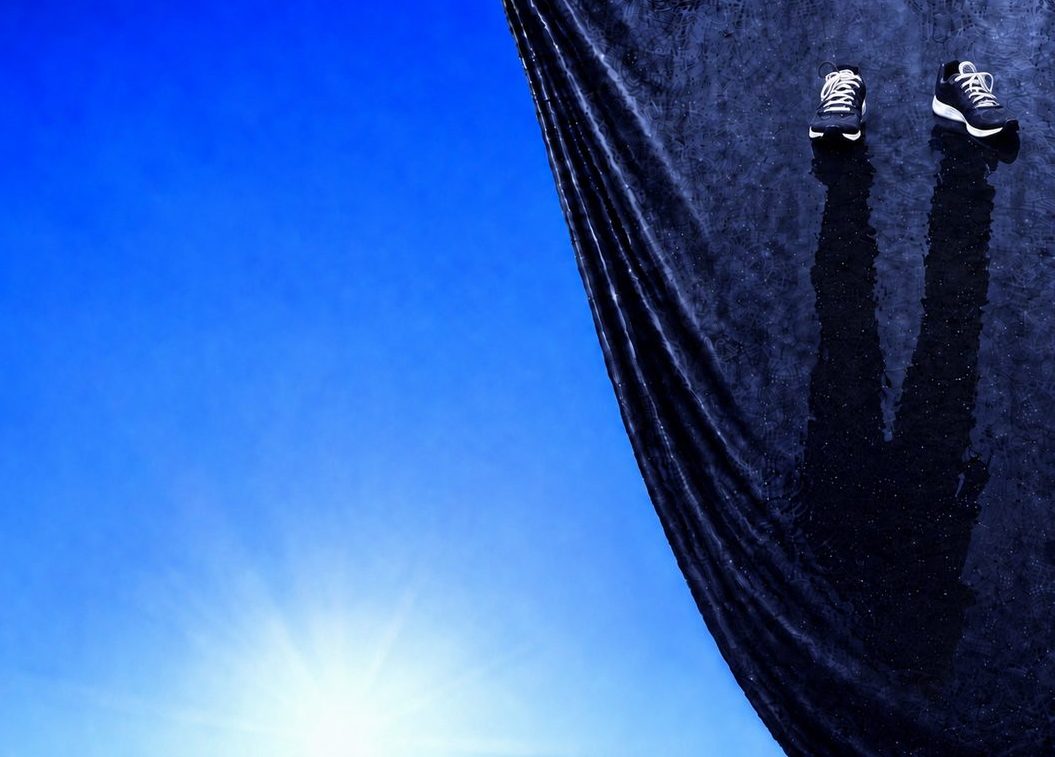 Un grand rideau noir texturé, sur lequel se reflète l'ombre d'une silhouette, s'ouvre sur un ciel bleu lumineux et ensoleillé, symbolisant le cheminement intérieur pour sortir du trauma.